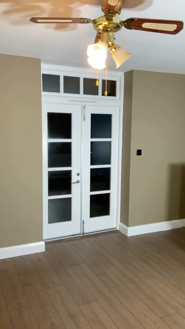 Room with French doors and ceiling fan decorated by Faughnan and Sons